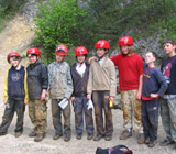 Grupa szkolna w czerwonych kaskach przed wejściem do jaskini Głębokiej